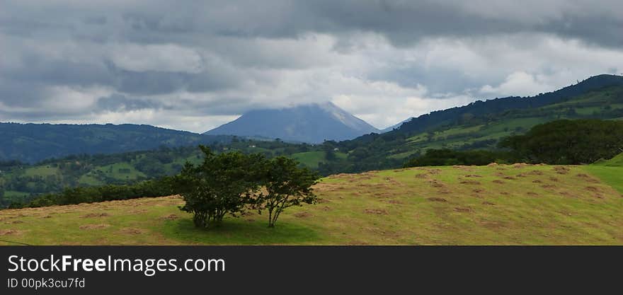 An active volcano in Costa Rica loom in the stormy background