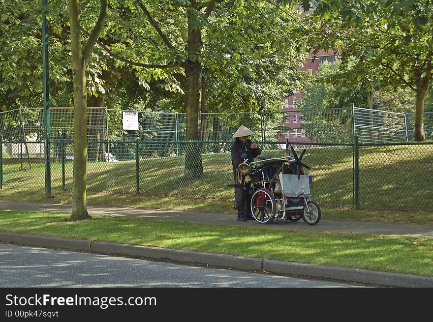 A anonymousjunk collector pushing a cart of oddities near a park in Vancouver. A anonymousjunk collector pushing a cart of oddities near a park in Vancouver.