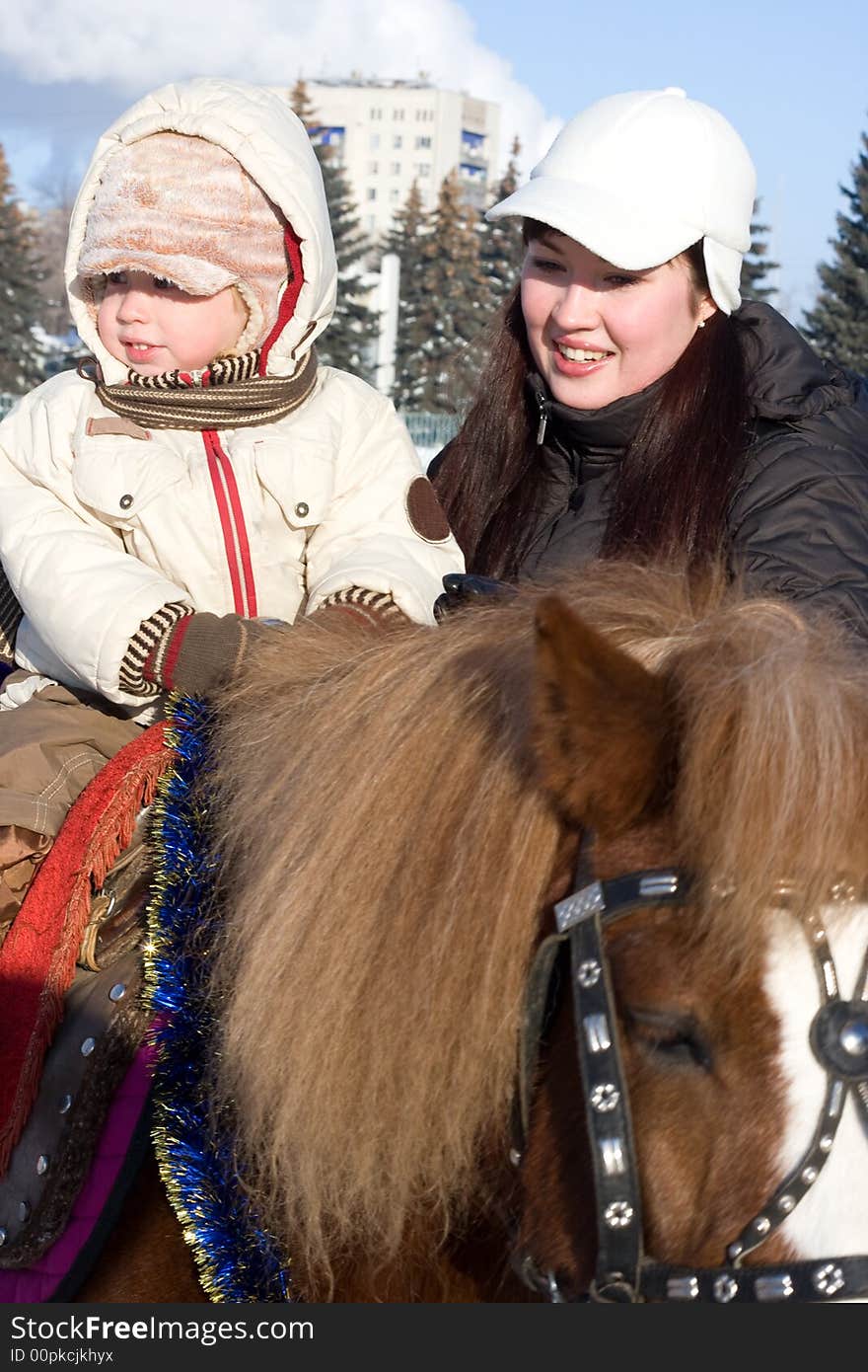 Mother and son at the horse walk, winter season. Mother and son at the horse walk, winter season