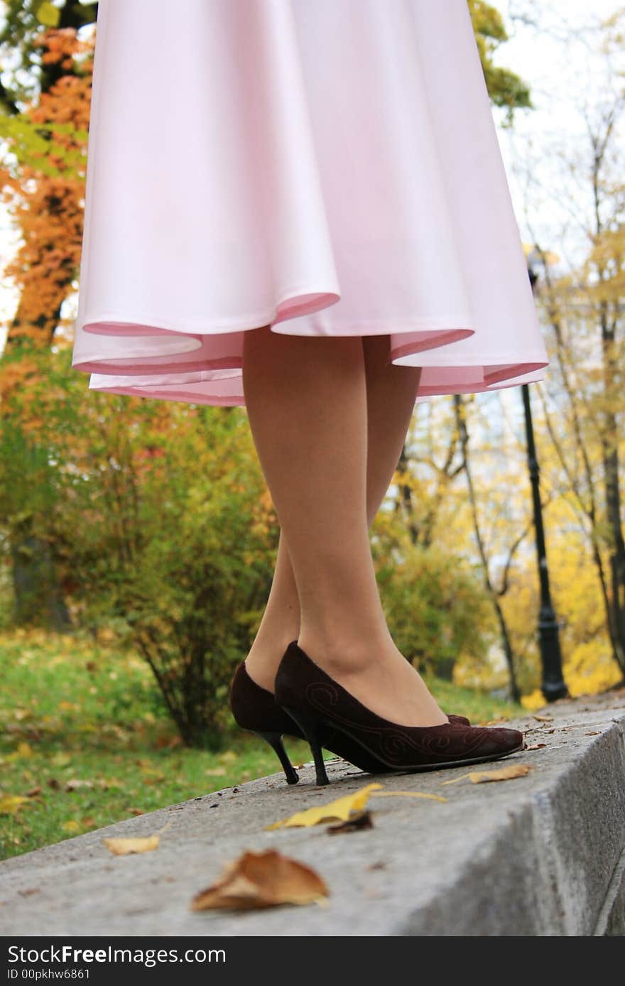 Beautiful legs in a pink skirt. Fall.