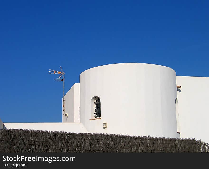 White spanish tower house with antenna on the wall