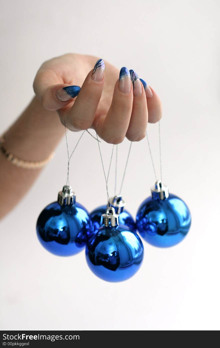 Female hand with manicure and blue balls. Female hand with manicure and blue balls