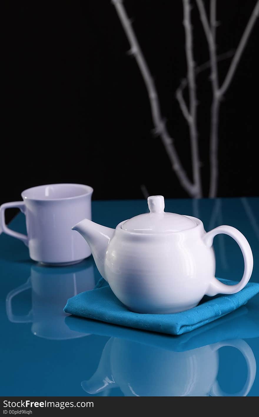 A modern table setting with a teapot and cup. A modern table setting with a teapot and cup