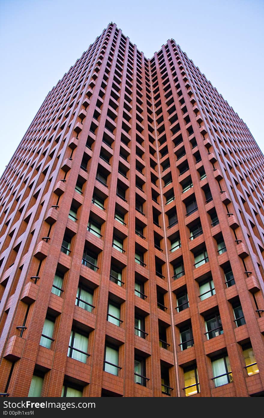 A photograph of a tall, red building at Tokyo's business district