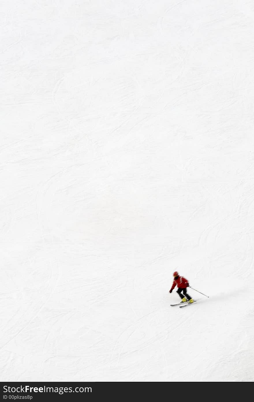 Winter scene: man moving down from the top of the mountain. The skier is motion blurred