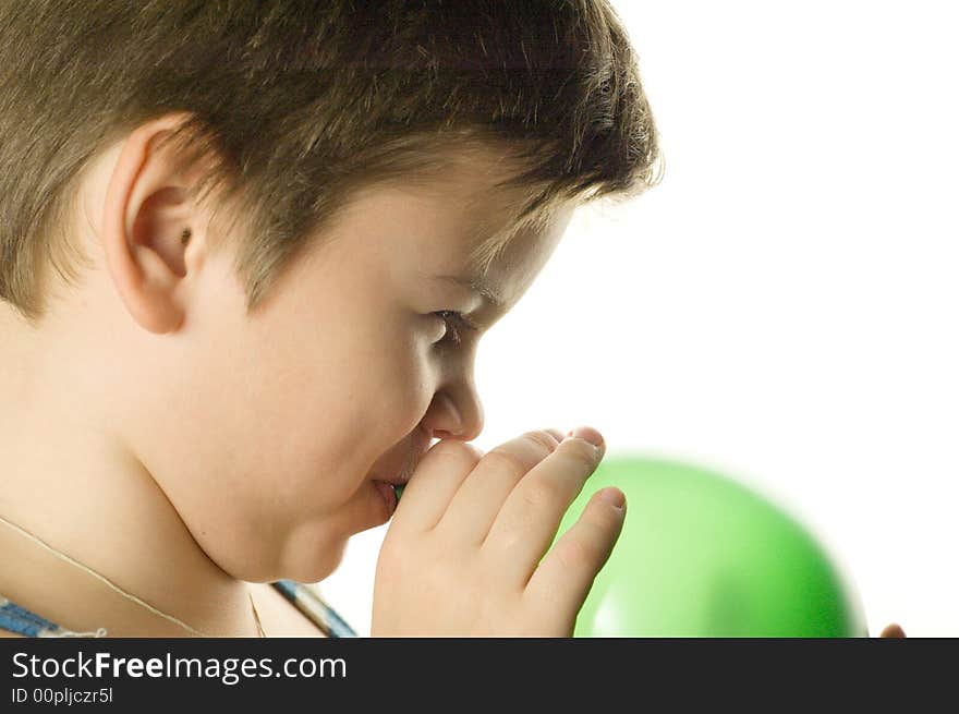 The boy inflates a green balloon on a white background. The boy inflates a green balloon on a white background