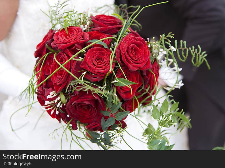Beautifull red roses in a wedding bouquet held by the bride