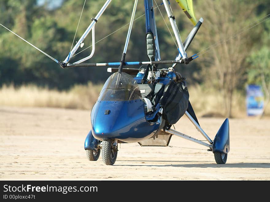 Blue microlight airplane on a dirt airfield. Blue microlight airplane on a dirt airfield