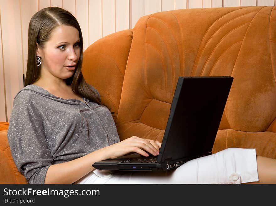 Young women working at laptop and read shocking message