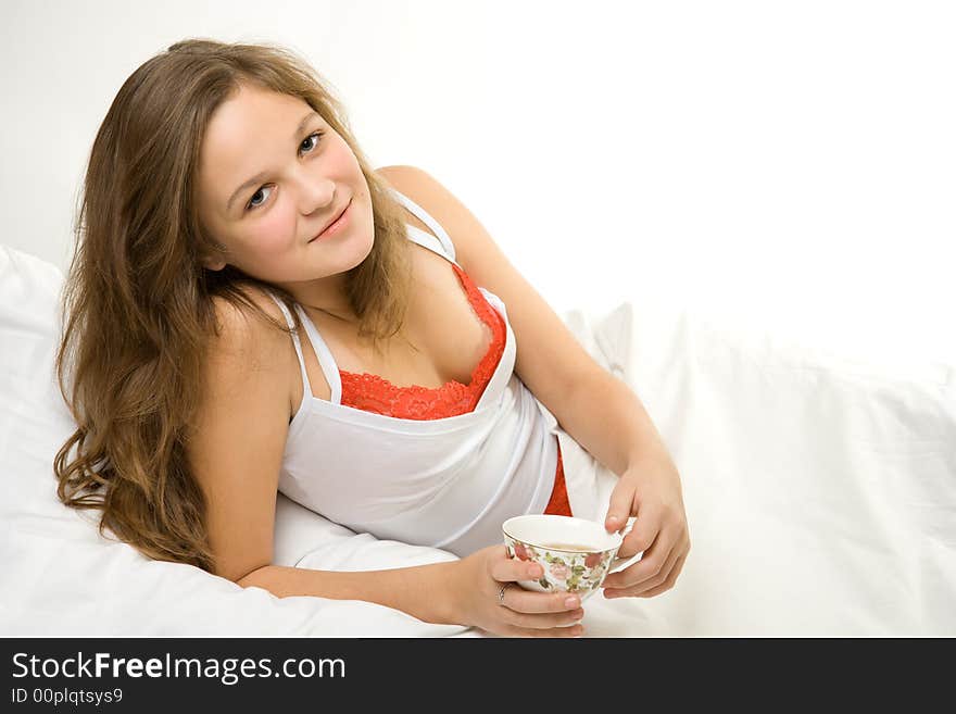 Young girl drinking tea in bed