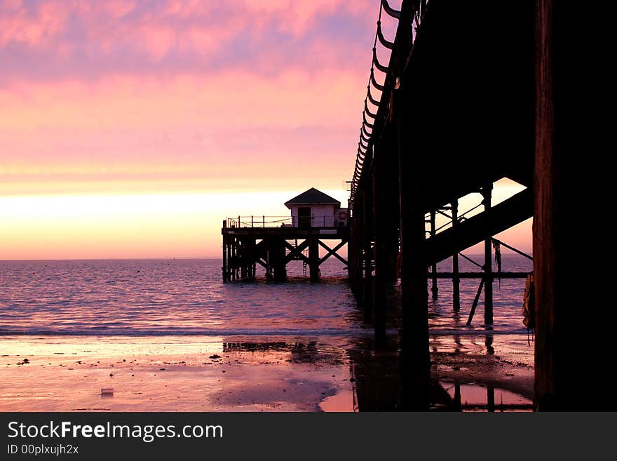 Sand, waves, and pier against sunset. Sand, waves, and pier against sunset