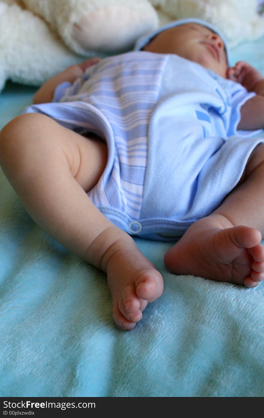 Week old baby boy in early morning light, focus on feet
