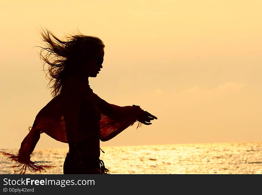 Girl silhouette on golden sunset sky background