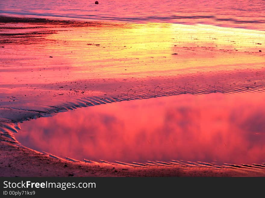 Sunset reflected in pool of water on beach. Sunset reflected in pool of water on beach