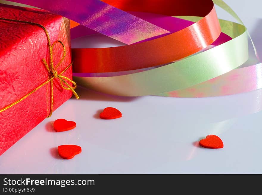 The present box, multicolored ribbon and some small hearts