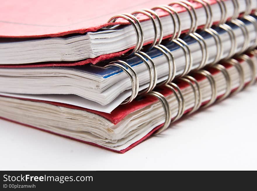 A stack of three lesson plan books with metal coil binding.