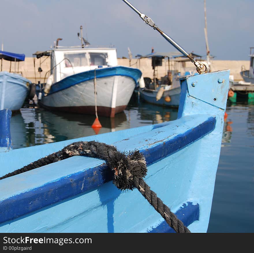 Part of the old blue boat against the background of port. Part of the old blue boat against the background of port