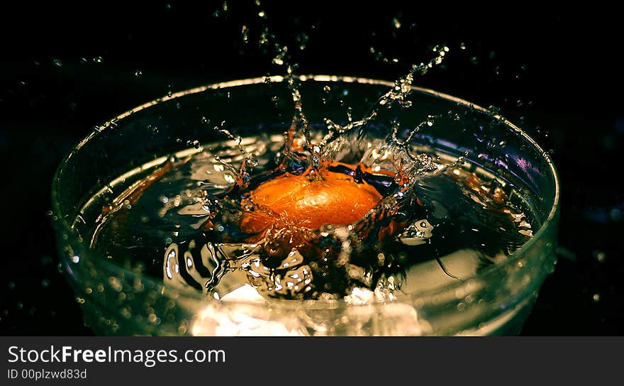 The moment while the orange fall in the water. The moment while the orange fall in the water.