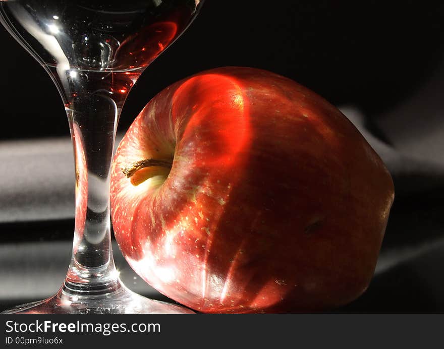 Wineglass and fresh red apple