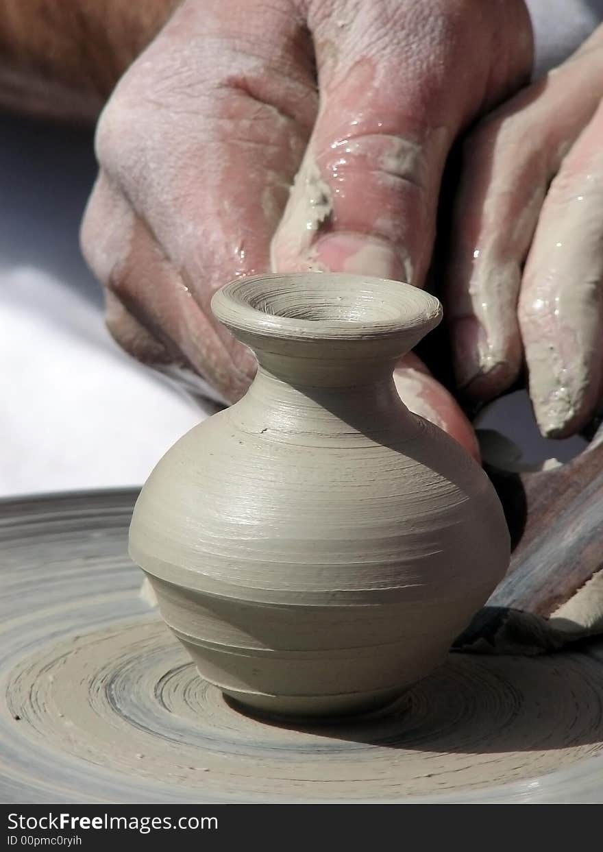 The master cuts out a pattern on a clay jug