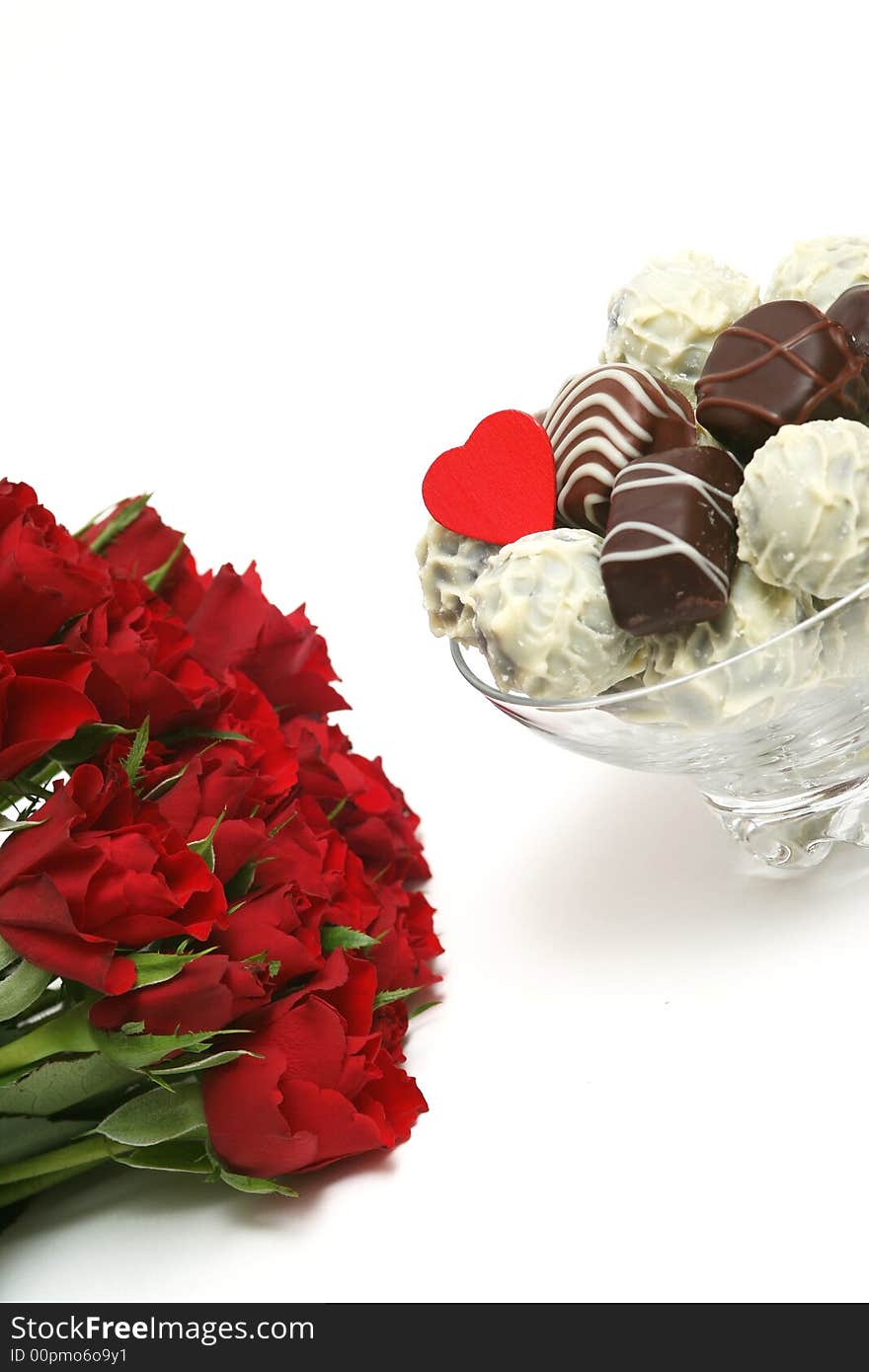 Mixed delicious chocolates with heart and a red rose on white background. Mixed delicious chocolates with heart and a red rose on white background.