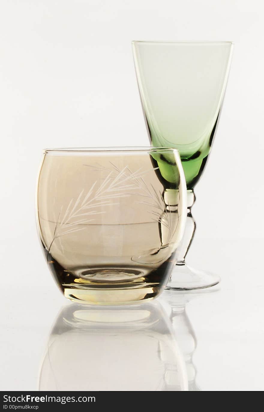 A glass beside a stack of white plates - on white background. A glass beside a stack of white plates - on white background