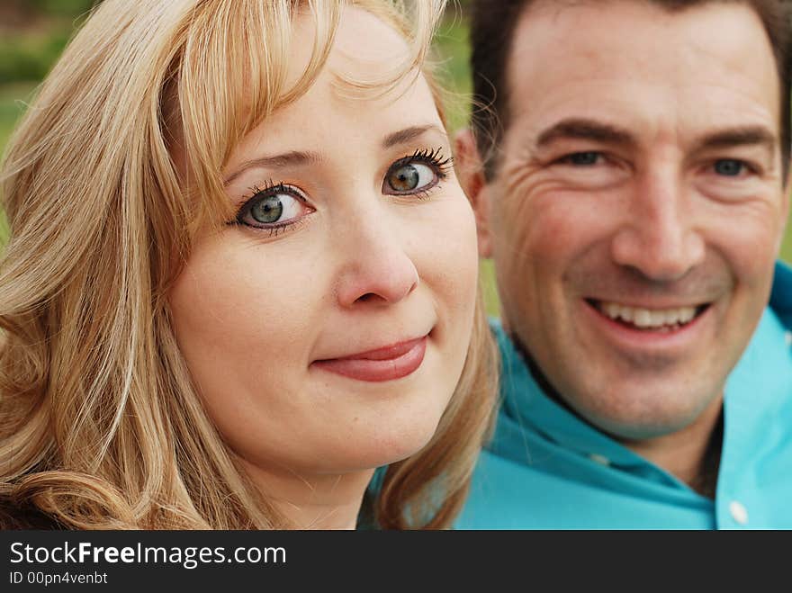 Happy couple is smiling in green park environment