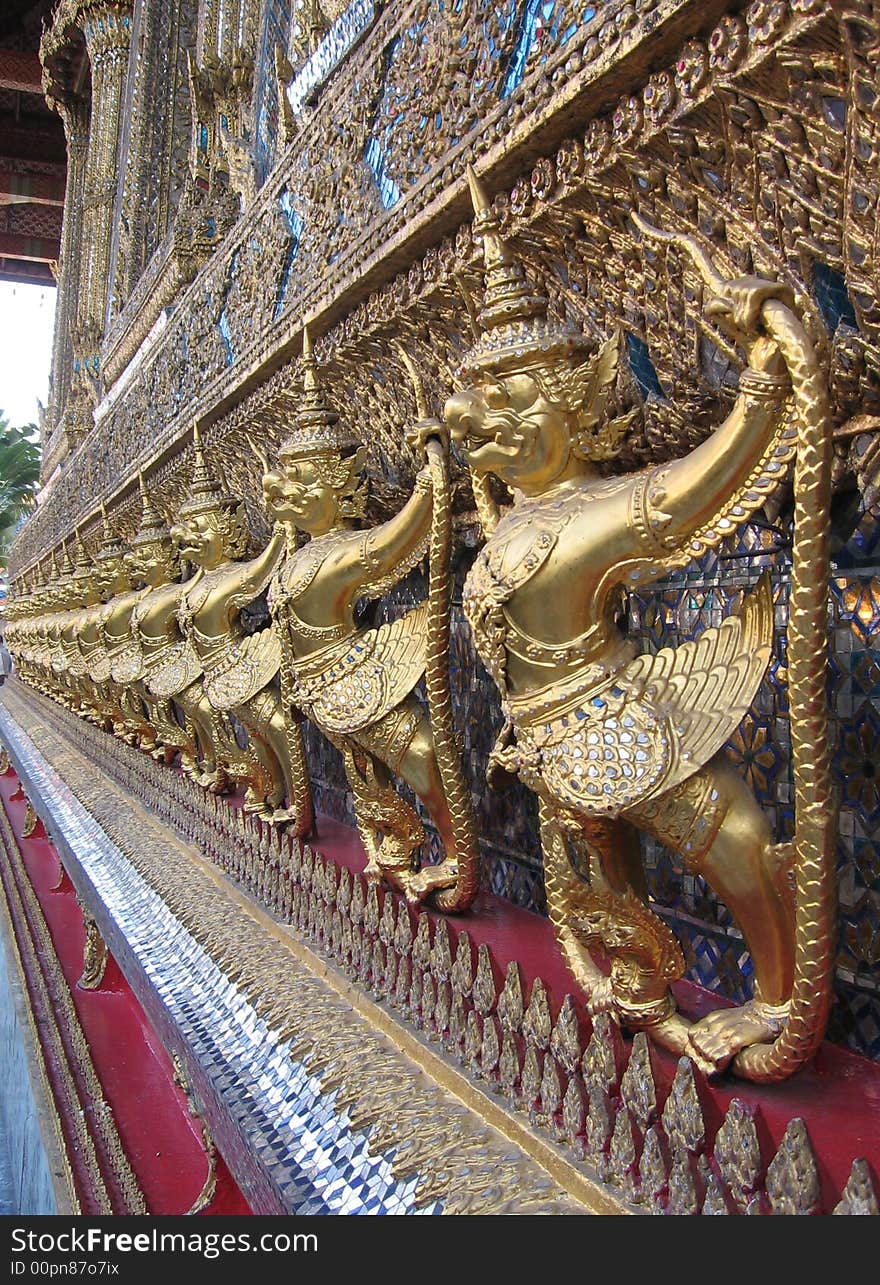 A row of statues on the wall of a temple in Bangkok. A row of statues on the wall of a temple in Bangkok