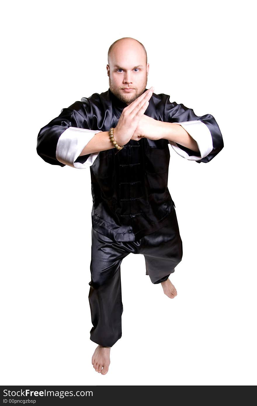 Man in kimono outfit in position for karate moves.