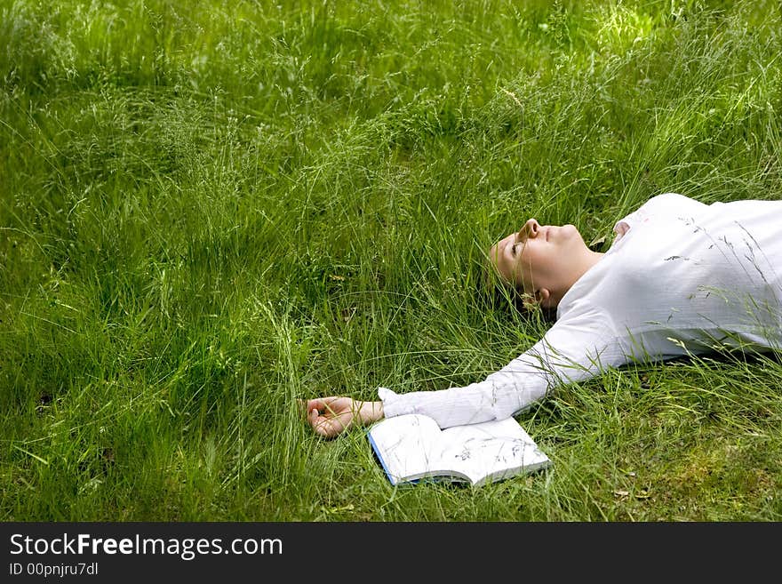 Student with book on meadow