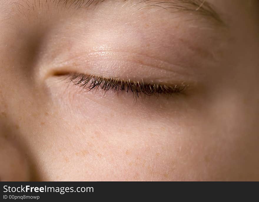 Closeup of a young boy's eye that is closed. Main focus is on the eyelashes. Closeup of a young boy's eye that is closed. Main focus is on the eyelashes.