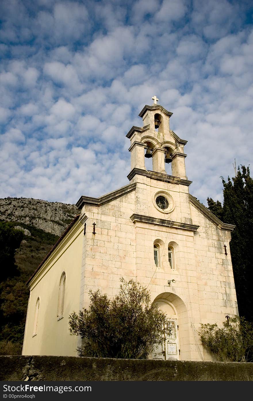 White stone old church against a background of blue sky and white clouds. White stone old church against a background of blue sky and white clouds