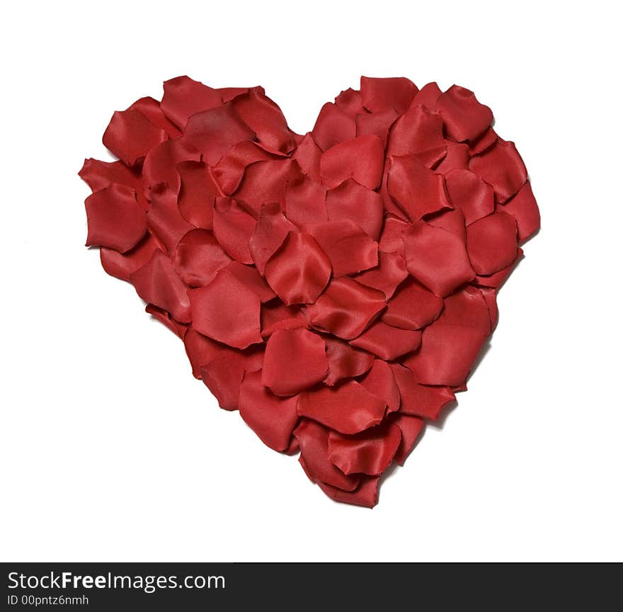 Red silk rose petals in a heart shape isolated on a white background. Red silk rose petals in a heart shape isolated on a white background.