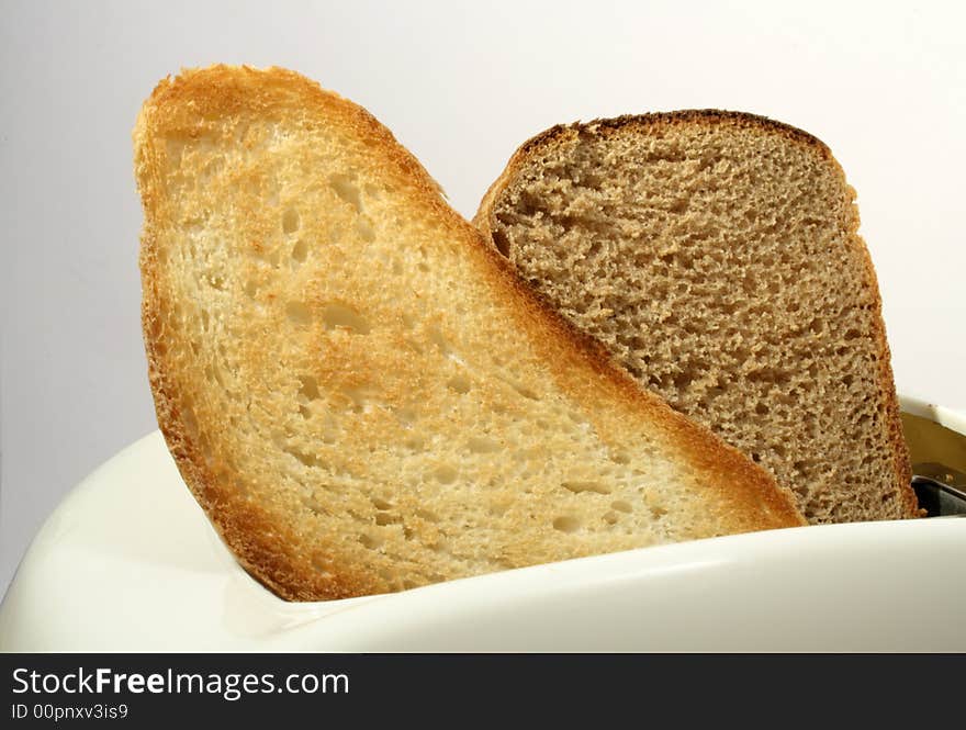 White toaster with white bread toast and rye-bread toast on white background