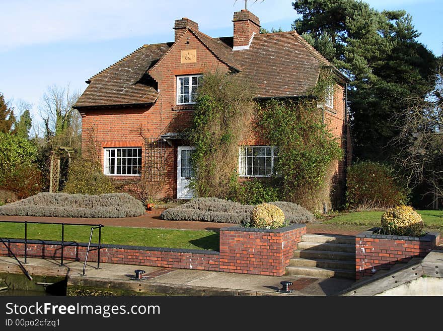 Lock keepers house on the River Thames in England with a pretty garden to the front