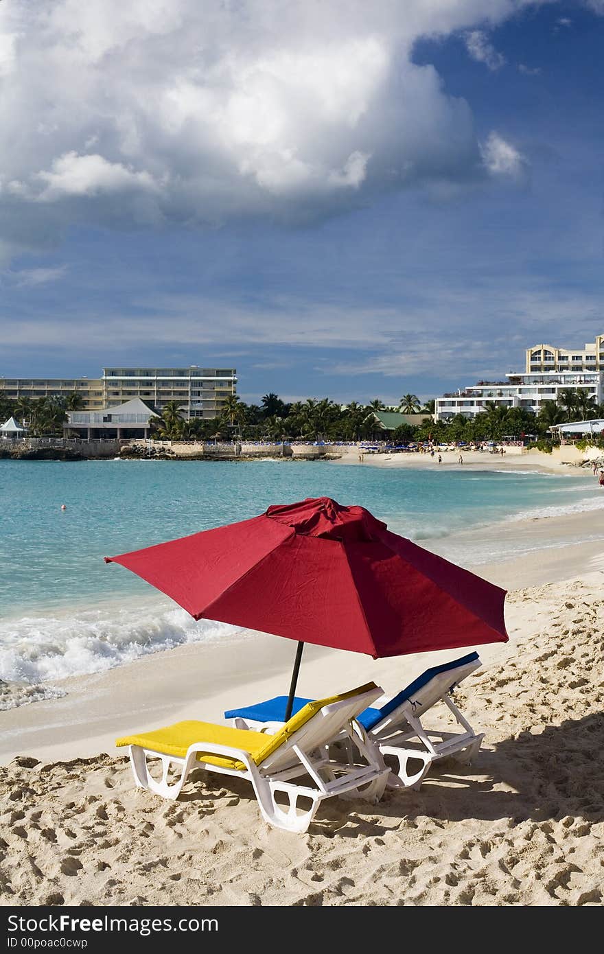 Two colorful chairs and umbrella on resort beach, St. Martin. Two colorful chairs and umbrella on resort beach, St. Martin