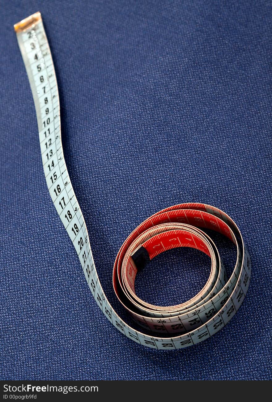 Measuring tape coiled on blue