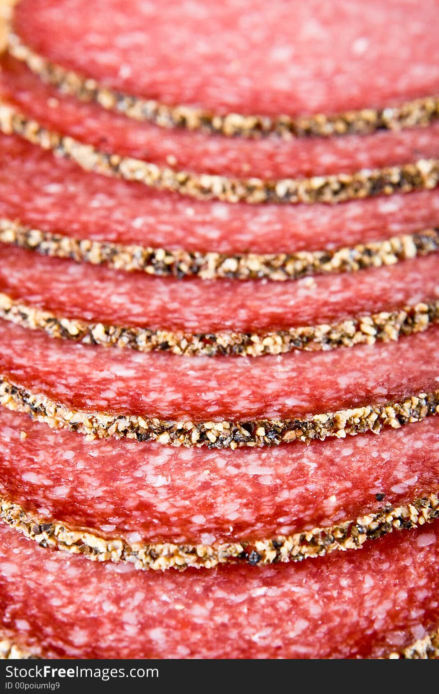 Peppered salami on a wooden chopping block