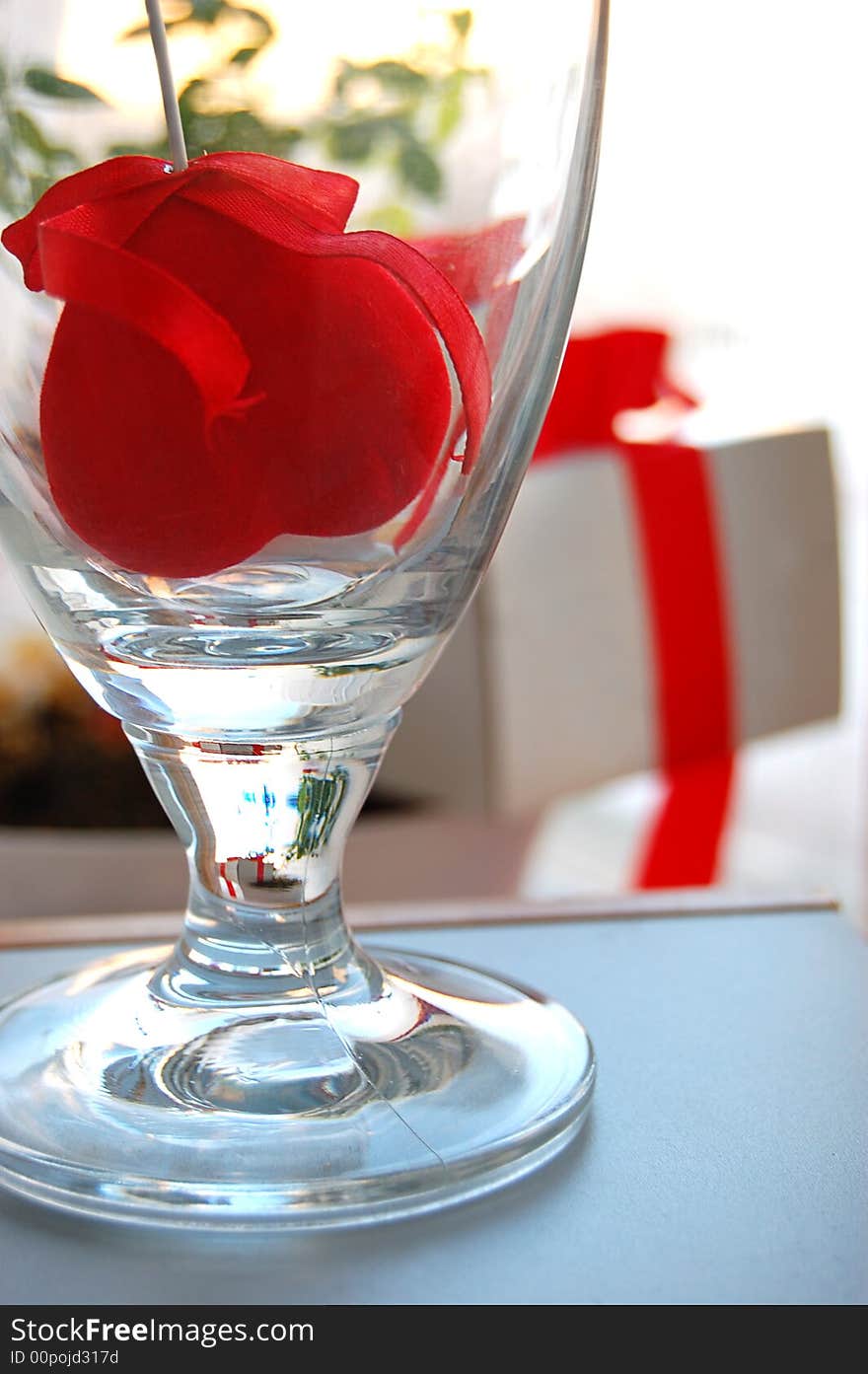 Gift box with red ribbon and fabric heart inside the glass. Gift box with red ribbon and fabric heart inside the glass