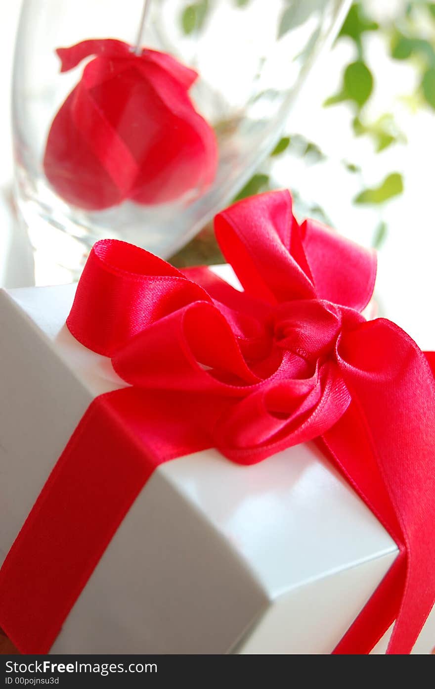 Gift box with red ribbon and fabric heart inside the glass. Gift box with red ribbon and fabric heart inside the glass