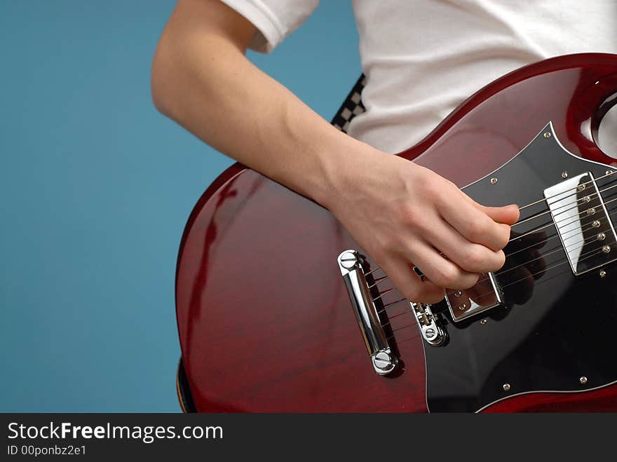 Horizontal shot of an electric guitar closeup with a male playing hand