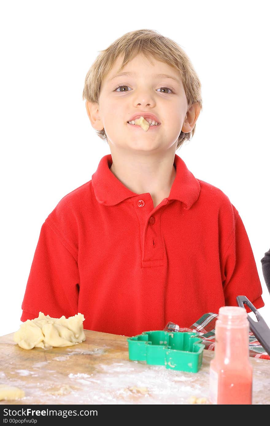 Happy child eating batter isolated on white