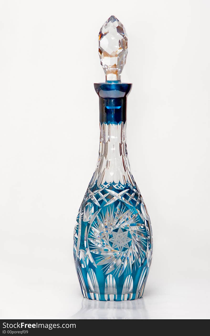 Ancient cristal decanter with reflection over white background