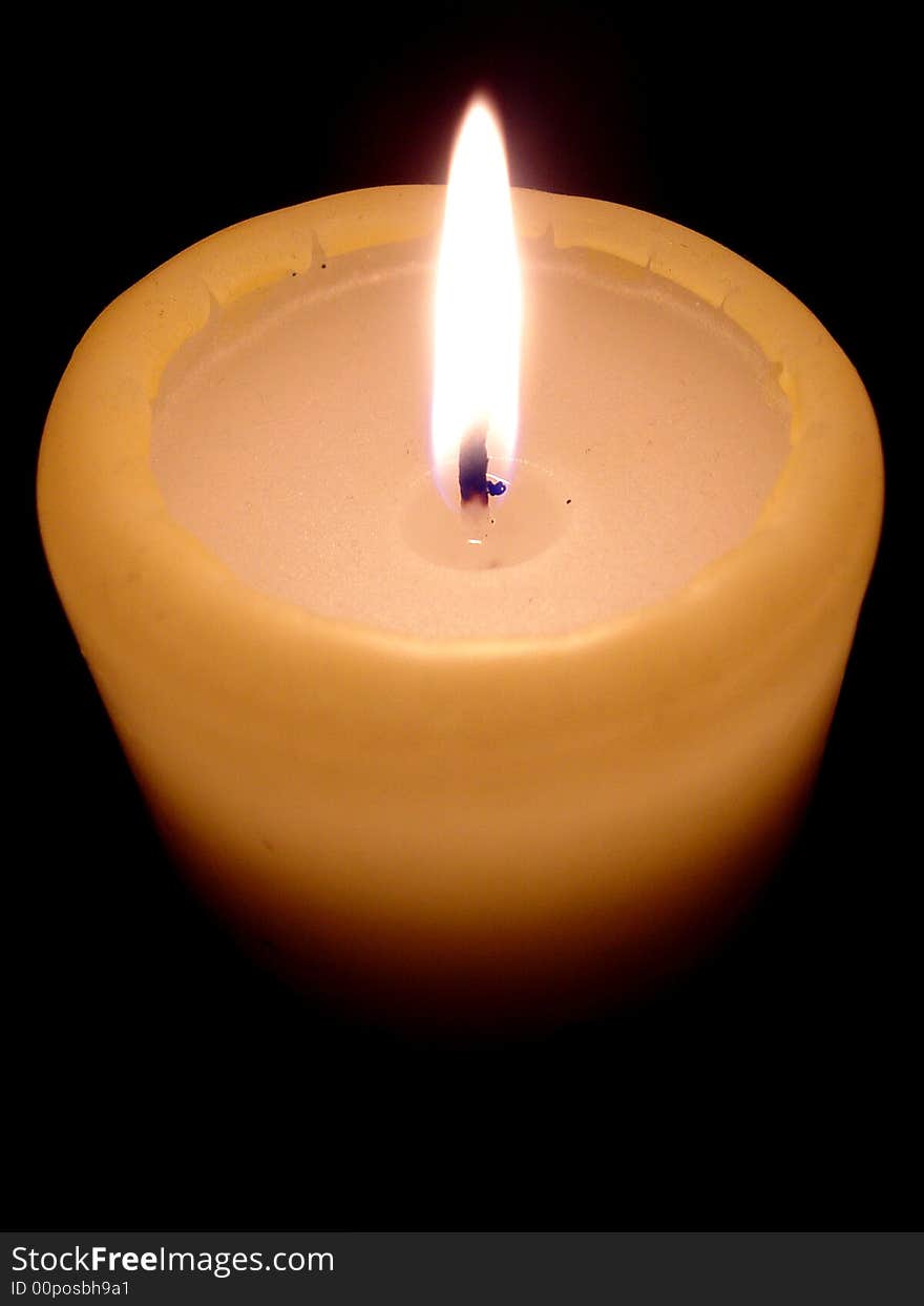 Burning candle on black background