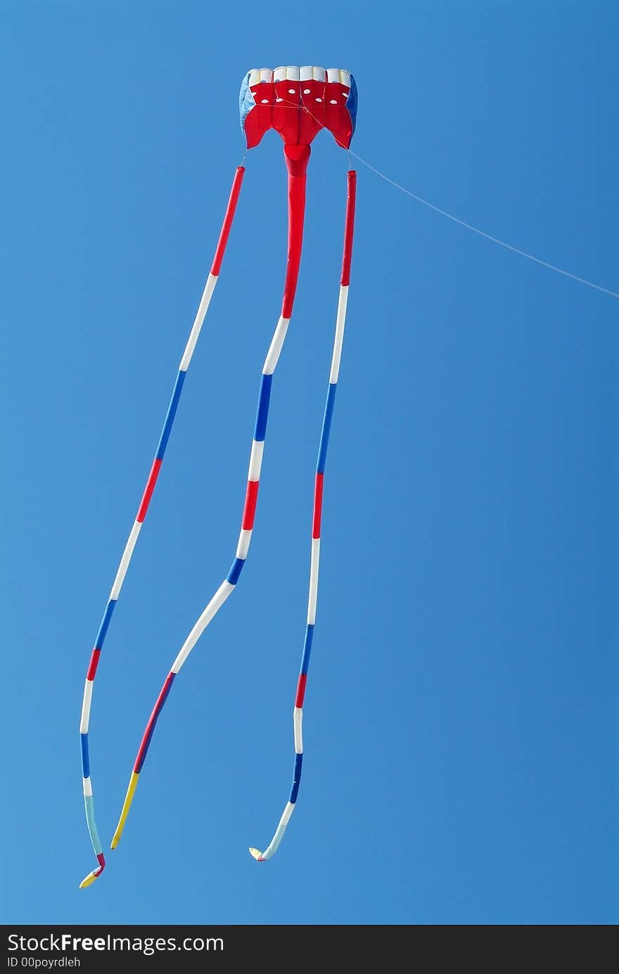 Red, white and blue kite on a blue sky background