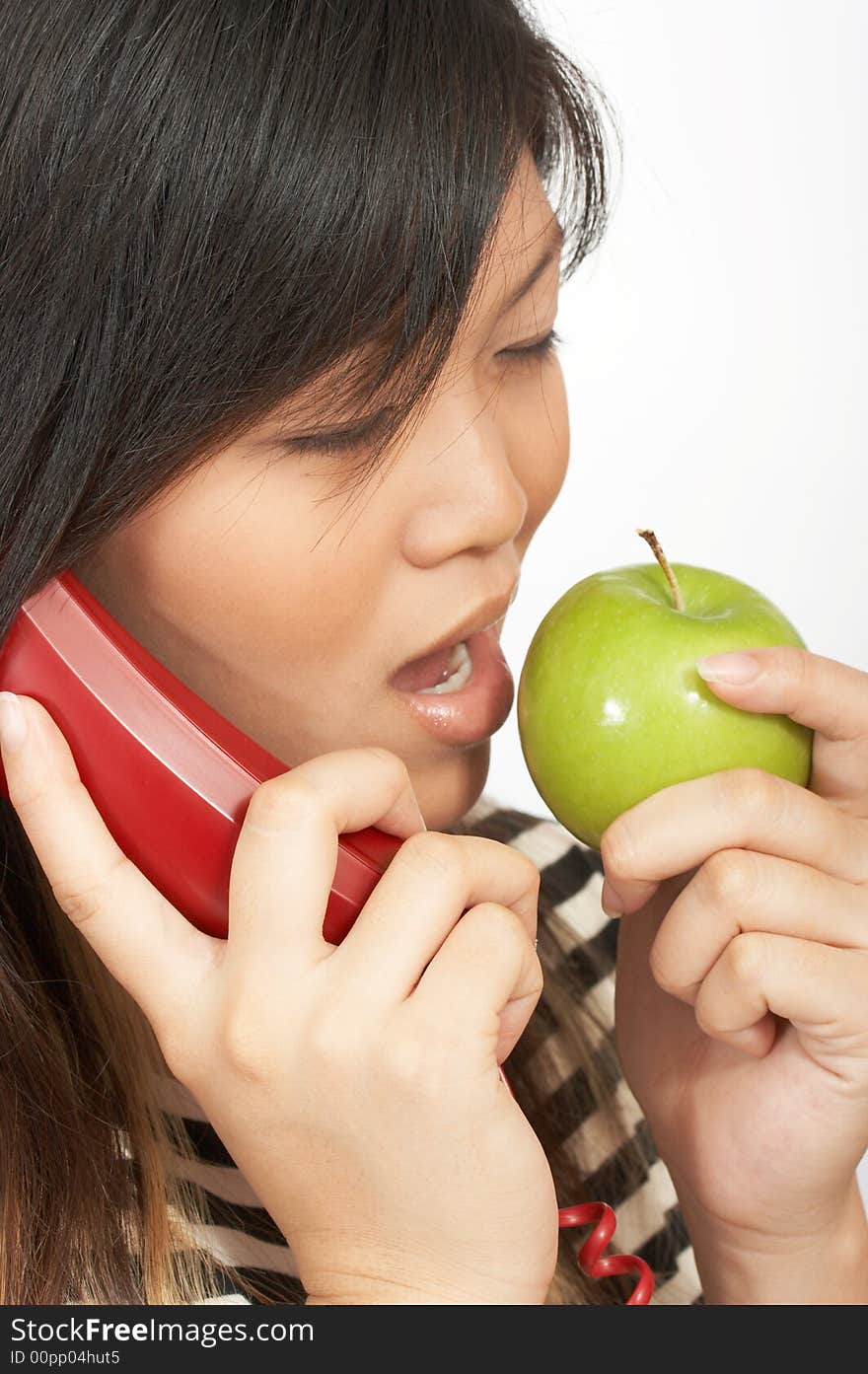 A woman eating an apple while on the phone. A woman eating an apple while on the phone