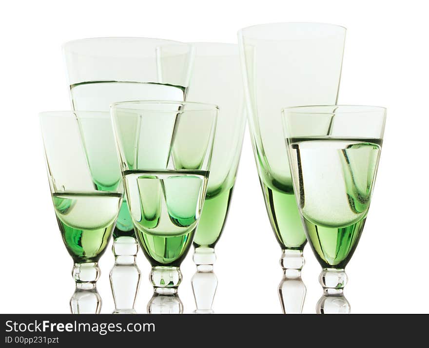 A glass beside a stack of white plates - on white background. A glass beside a stack of white plates - on white background