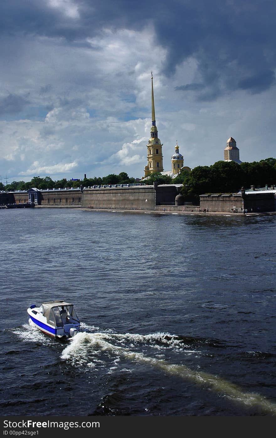 View to the Peter and Paul fortress from Troitsky bridge. Boat sailing over the Neva river.