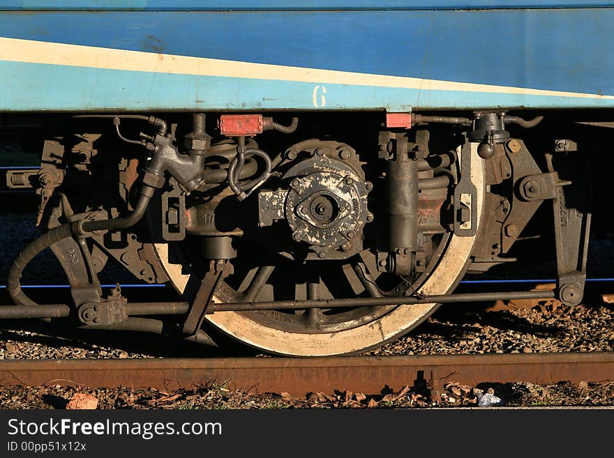 Wheel of a train costing at station. A fragment of the locomotive