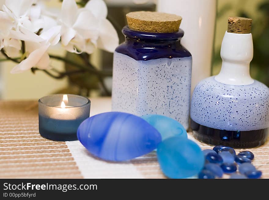 A decorative composition of blue vases and glass pebbles, orchid flower in the background. MORE SPA COMPOSITIONS ». A decorative composition of blue vases and glass pebbles, orchid flower in the background. MORE SPA COMPOSITIONS »